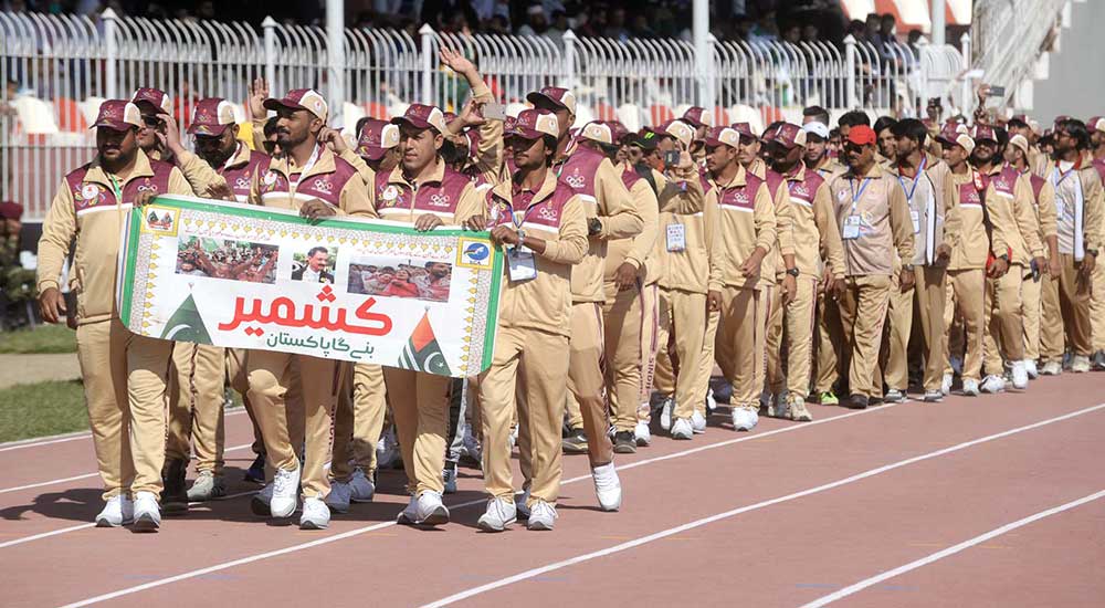 Athletes march ahead holding banners during the inauguration ceremony.