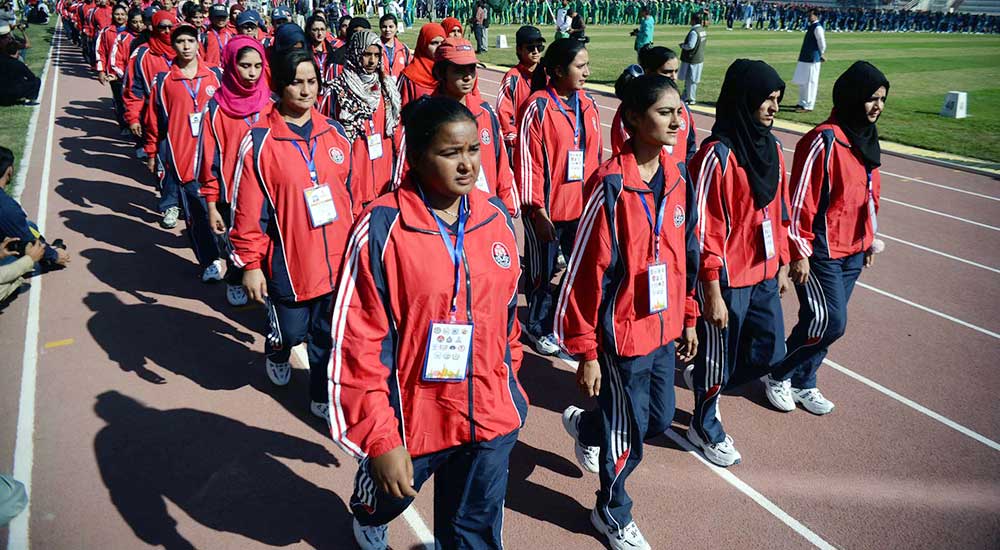 Women athletes in their sports kit, march ahead.